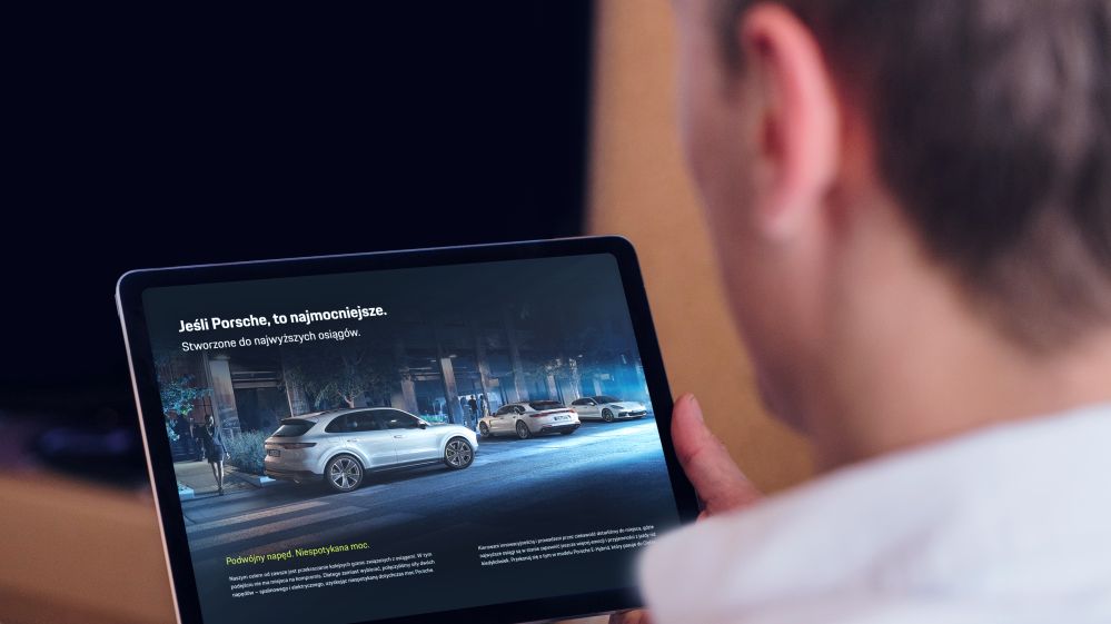 Porsche e hybrid kampania landing page tablet w dłoni użytkownika