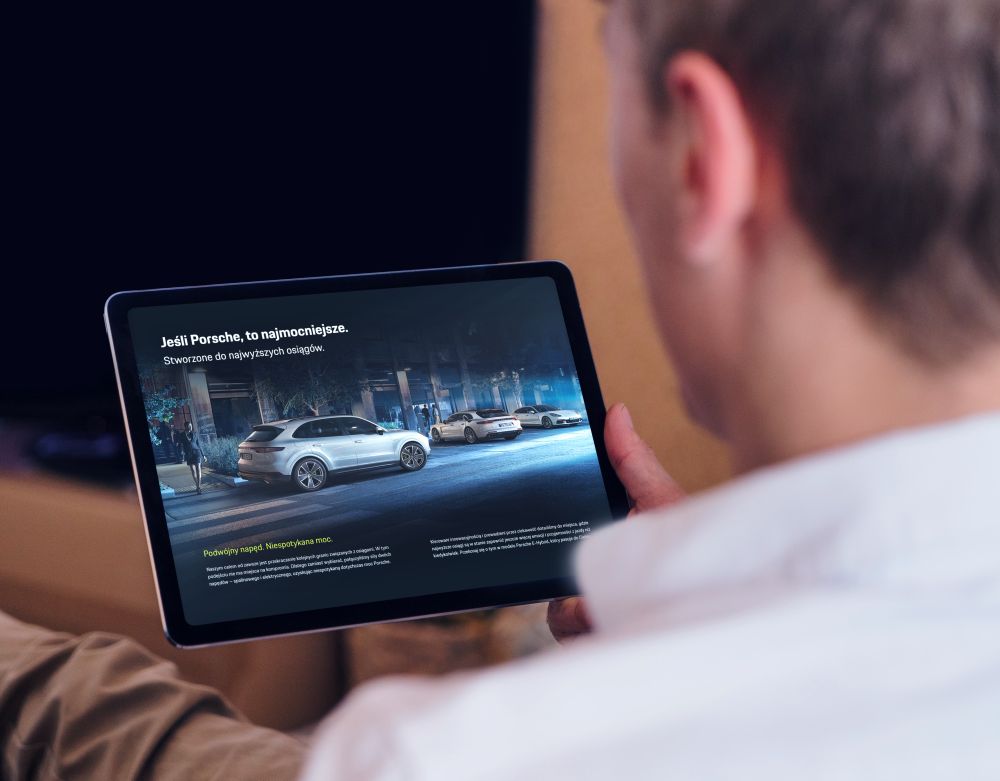 Porsche e hybrid kampania landing page tablet w dłoni użytkownika